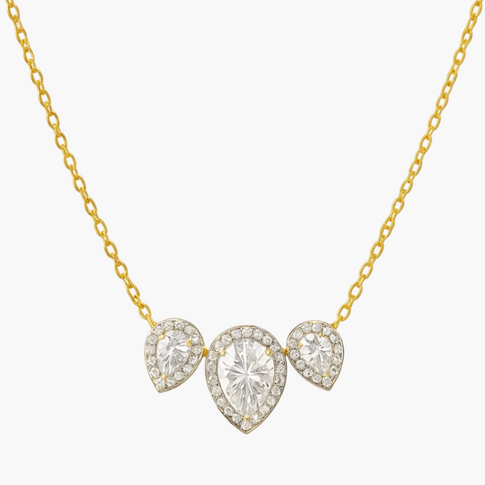 Gold necklace with three heart-shaped diamond pendants on a white background