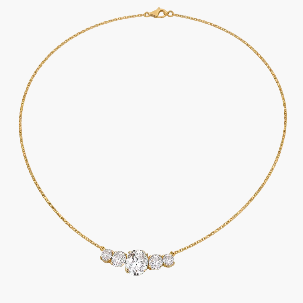 Gold necklace with a heart-shaped diamond pendant on a white background
