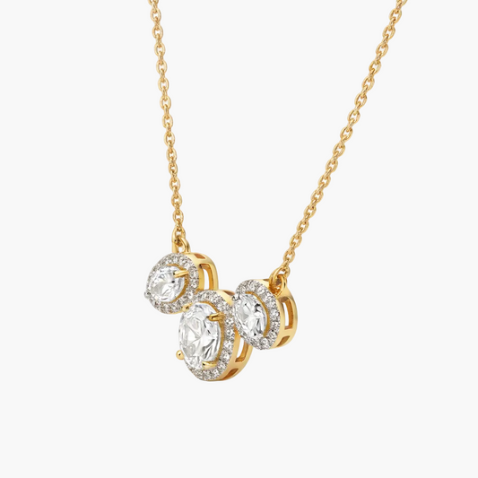 Gold necklace with three circular diamond pendants on a white background