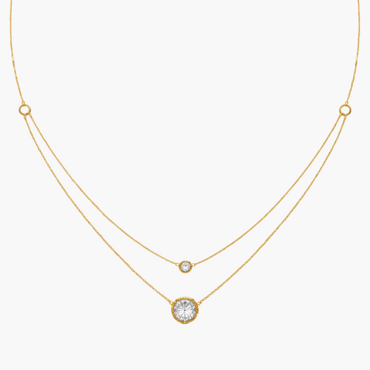 Gold necklace with three round gemstones on a white background