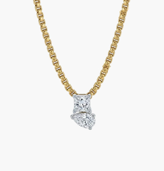 Gold necklace with a diamond pendant on a white background