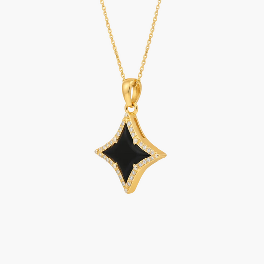 Gold pendant with a black stone on a white background