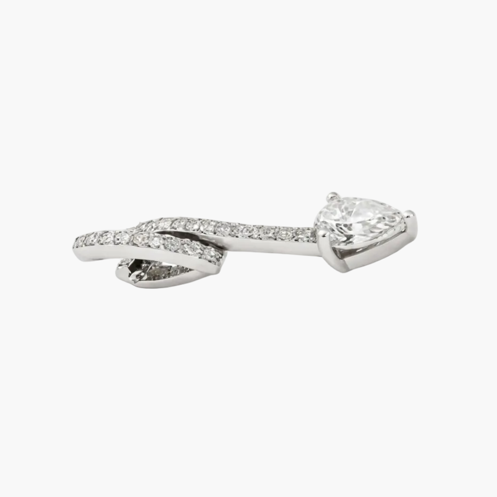 Silver bow-shaped earring with clear gemstones on a white background