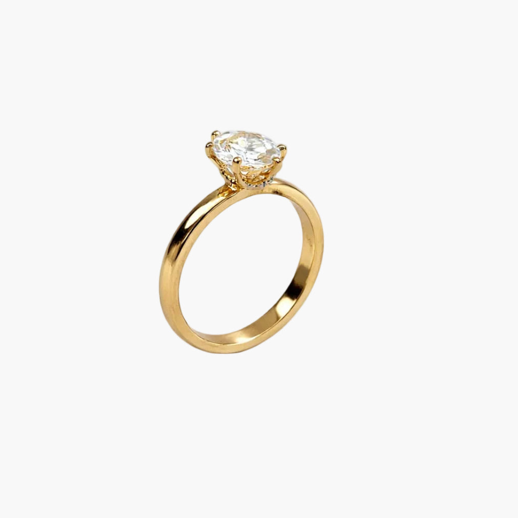 Gold ring with a clear gemstone on a white background