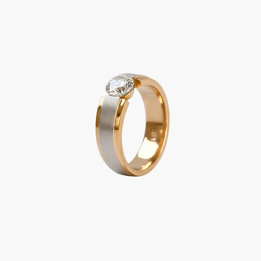 Two-tone gold ring with a diamond on a white background