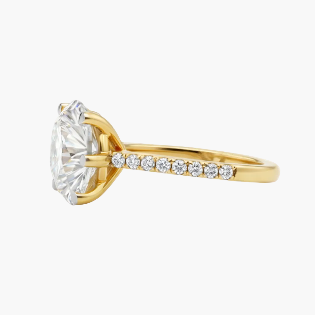 Gold ring with a large diamond and smaller diamonds on the band against a white background