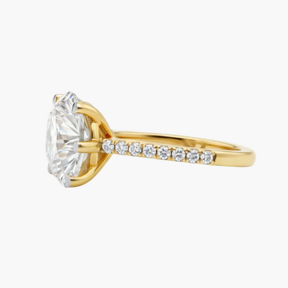 Gold ring with a large diamond and smaller diamonds on the band against a white background