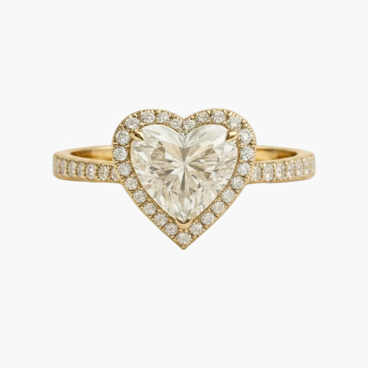 Heart-shaped diamond ring with gold setting on a white background
