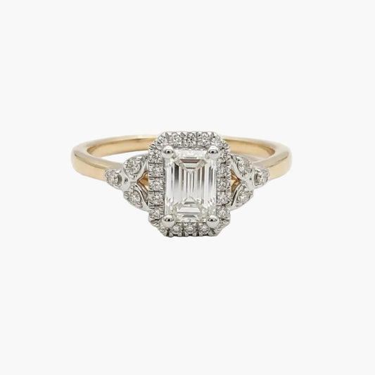 Diamond ring with a central emerald-cut stone and smaller diamonds on a light gray background