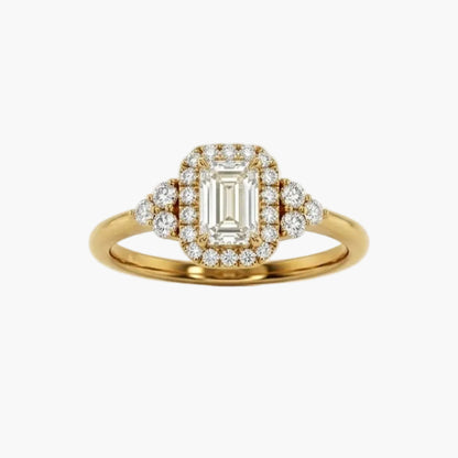 Gold ring with emerald-cut diamond and smaller diamonds on a white background