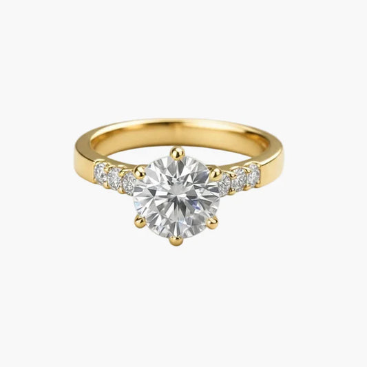 Gold ring with a large diamond and smaller diamonds on the band against a white background