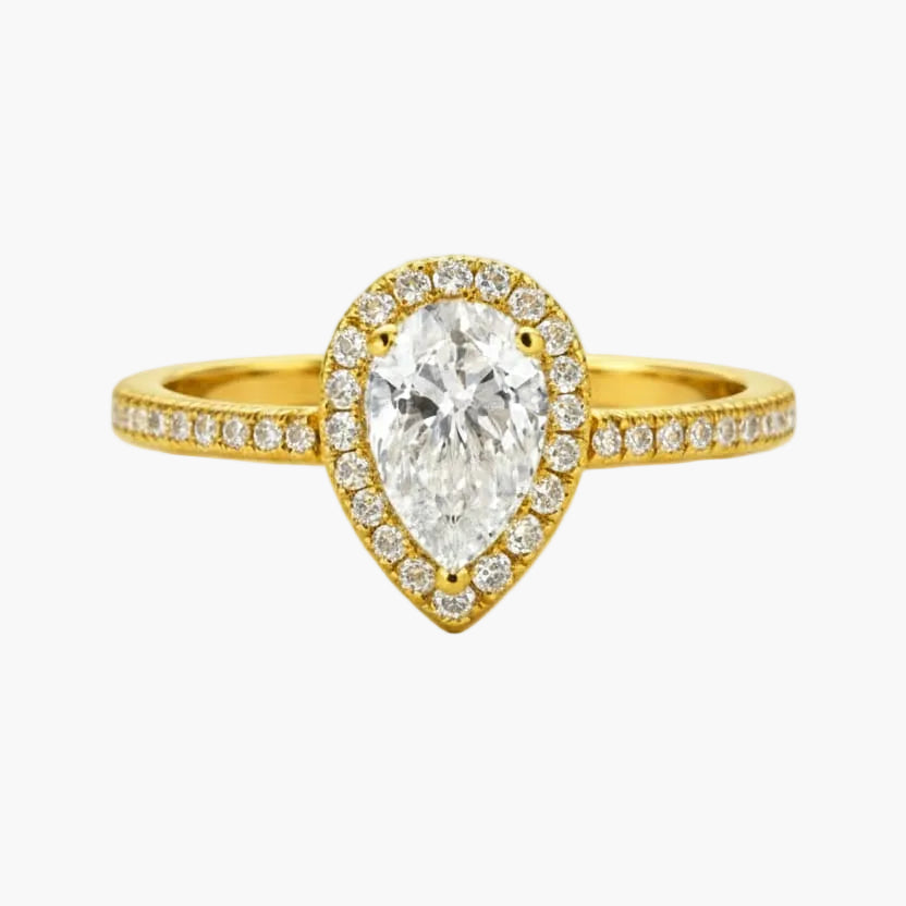 Gold ring with a pear-shaped diamond on a white background