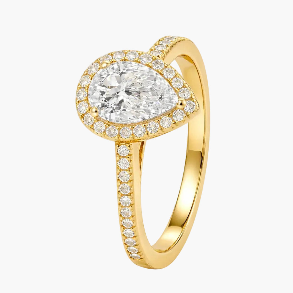Gold ring with a pear-shaped diamond and smaller diamonds on a white background