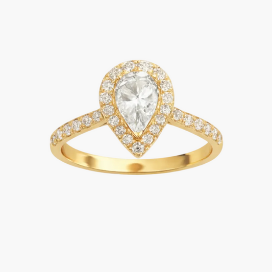 Gold ring with a pear-shaped diamond on a white background