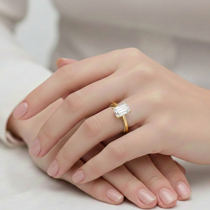 Gold ring with a diamond on a hand against a neutral background