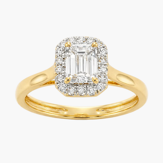 Gold ring with emerald-cut diamond and smaller diamonds on a white background
