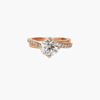 Rose gold ring with a large diamond and smaller diamonds on the band against a white background