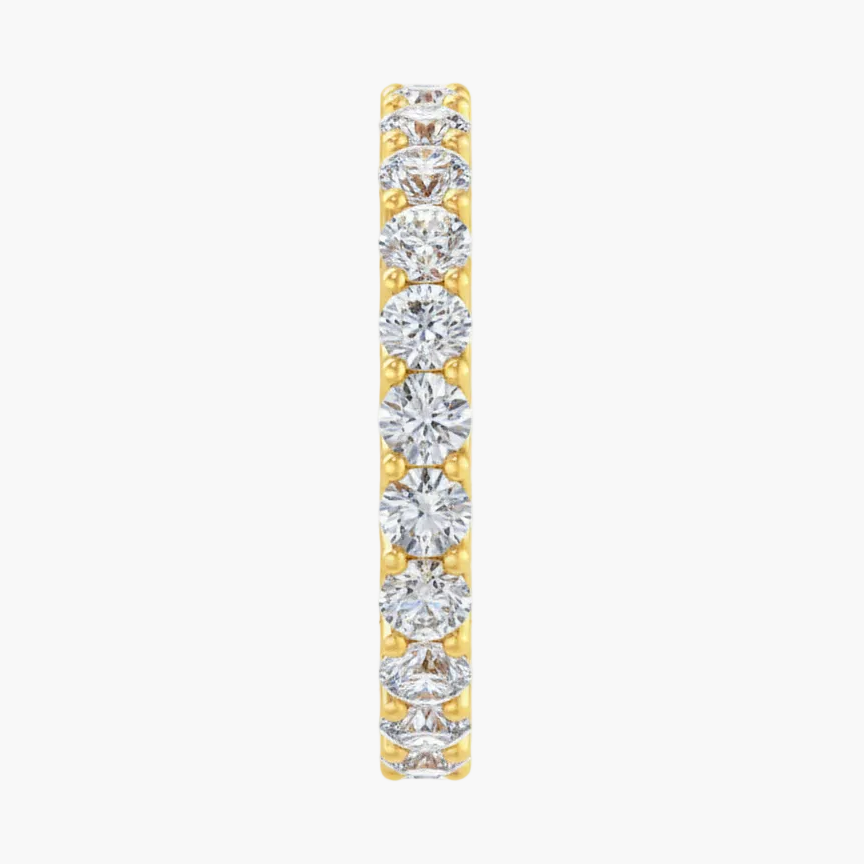 Diamond eternity band in yellow gold on a white background