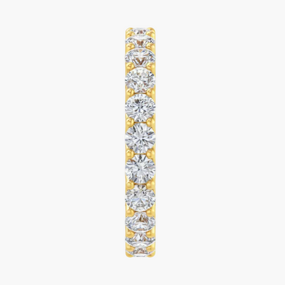 Diamond eternity band in yellow gold on a white background