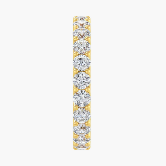 Diamond eternity band in yellow gold on a white background