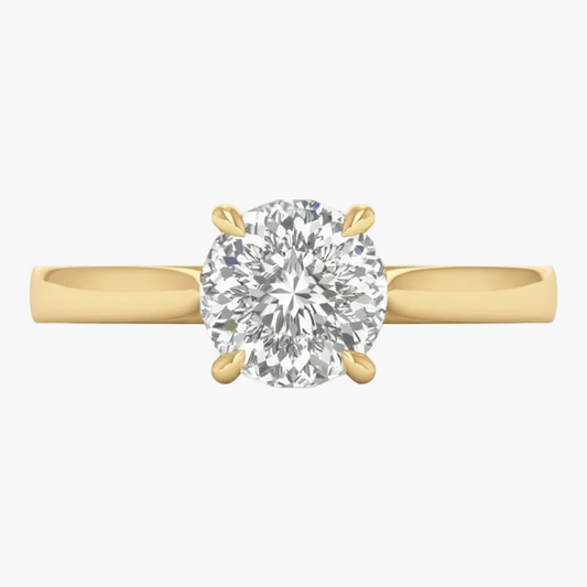 Gold ring with a large diamond on a light gray background