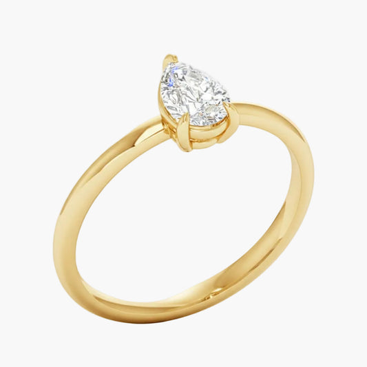 Gold ring with a pear-shaped diamond on a white background