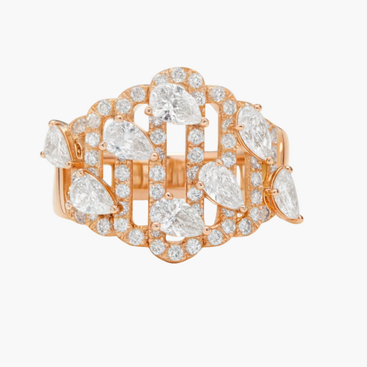 Rose gold ring with pear-shaped and round diamonds on a white background