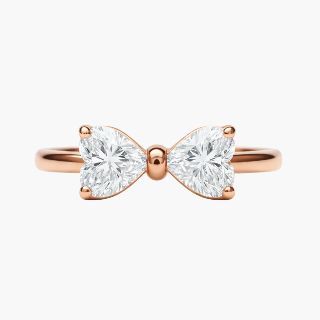 Rose gold bow-shaped ring with two heart-shaped diamonds on a white background