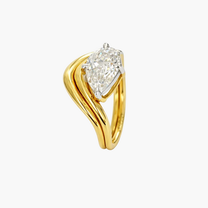 Gold ring with a pear-shaped diamond on a white background