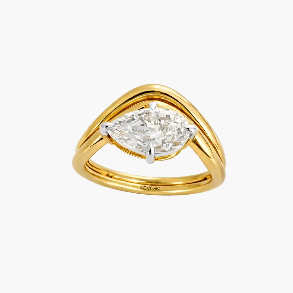 Gold ring with a pear-shaped diamond on a white background