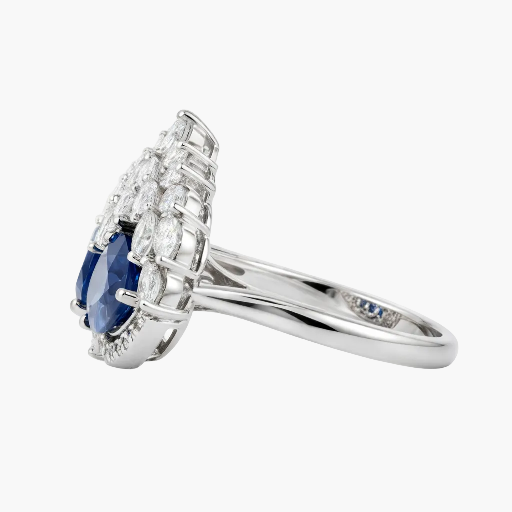 Silver ring with a blue gemstone and diamond accents on a white background
