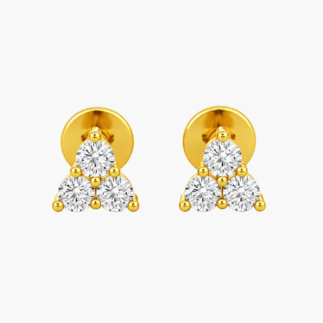A pair of gold triangular stud earrings with three clear round-cut gemstones in each earring, set against a plain white background.