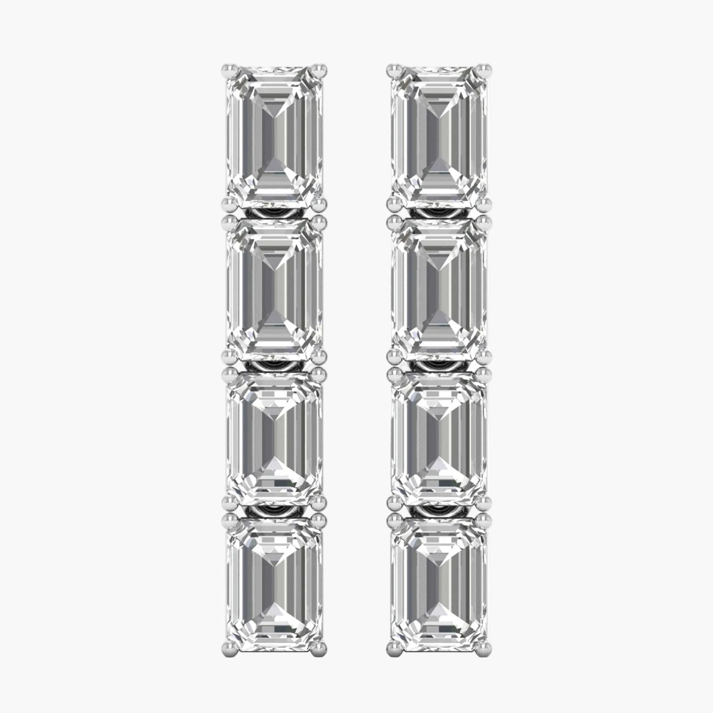 Pair of diamond earrings with emerald-cut stones on a white background
