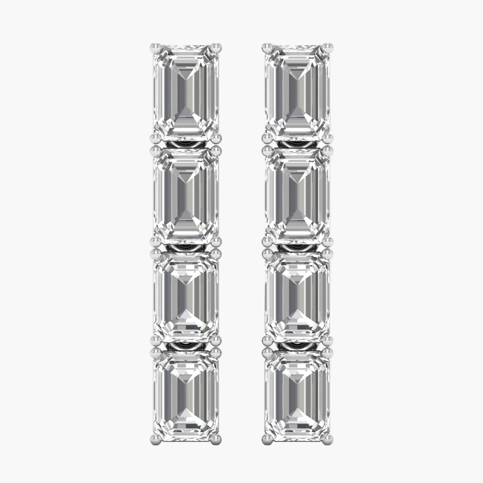 Pair of diamond earrings with emerald-cut stones on a white background