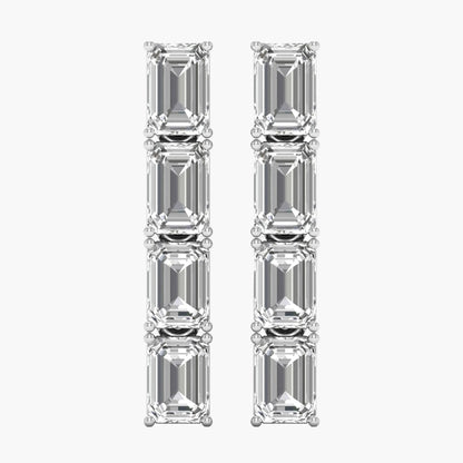 Pair of diamond earrings with emerald-cut stones on a white background