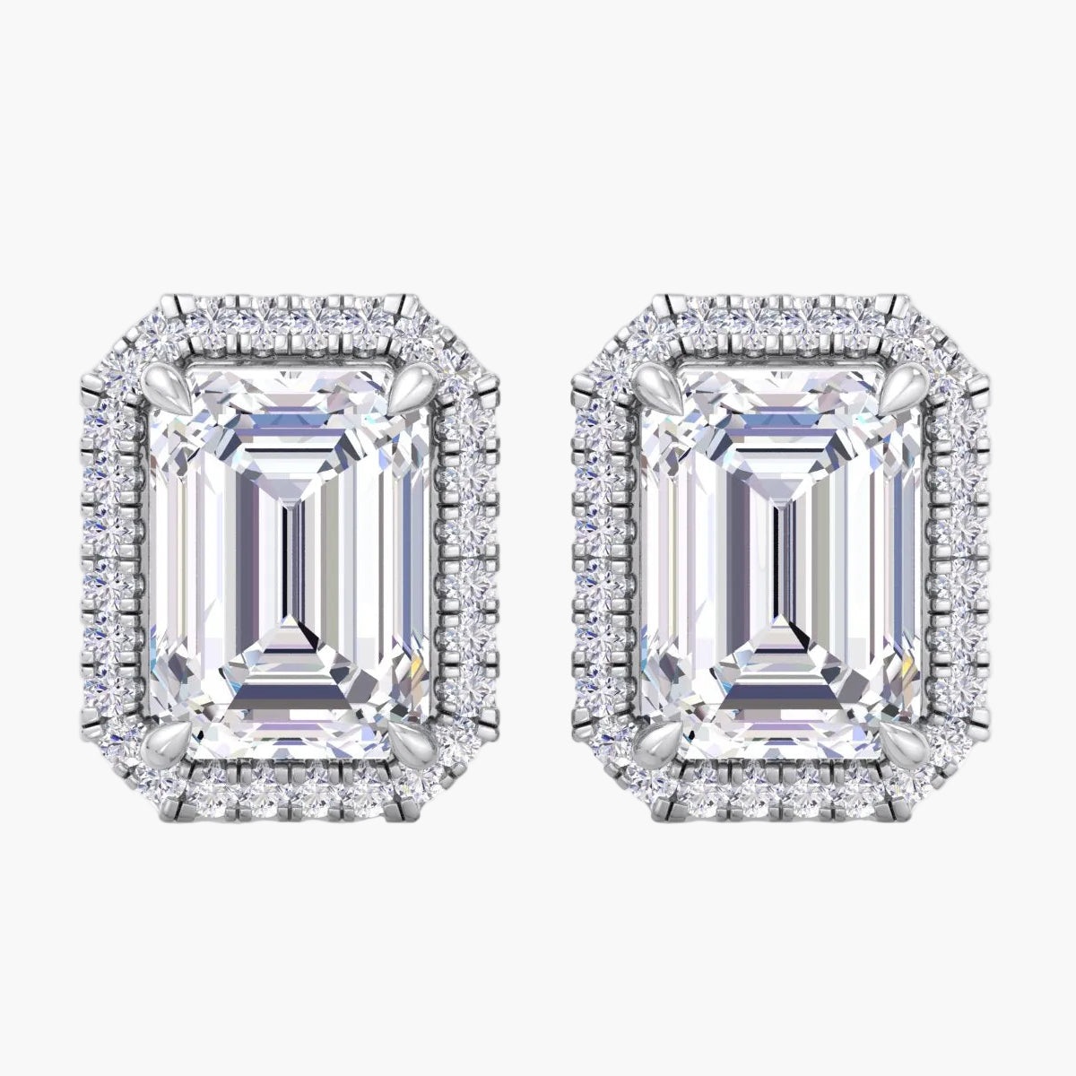Pair of diamond earrings with emerald-cut gemstones on a white background