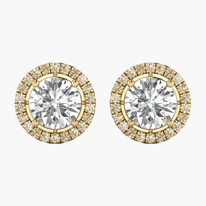 A pair of yellow gold stud earrings featuring a large round brilliant-cut center stone surrounded by a halo of smaller diamonds, shown on a plain white background.