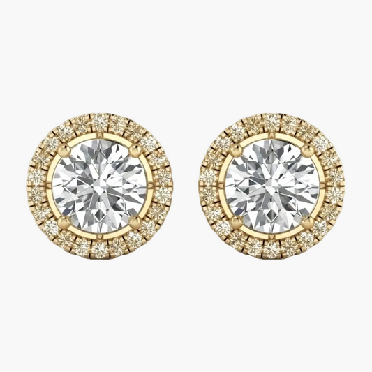 A pair of yellow gold stud earrings featuring a large round brilliant-cut center stone surrounded by a halo of smaller diamonds, shown on a plain white background.