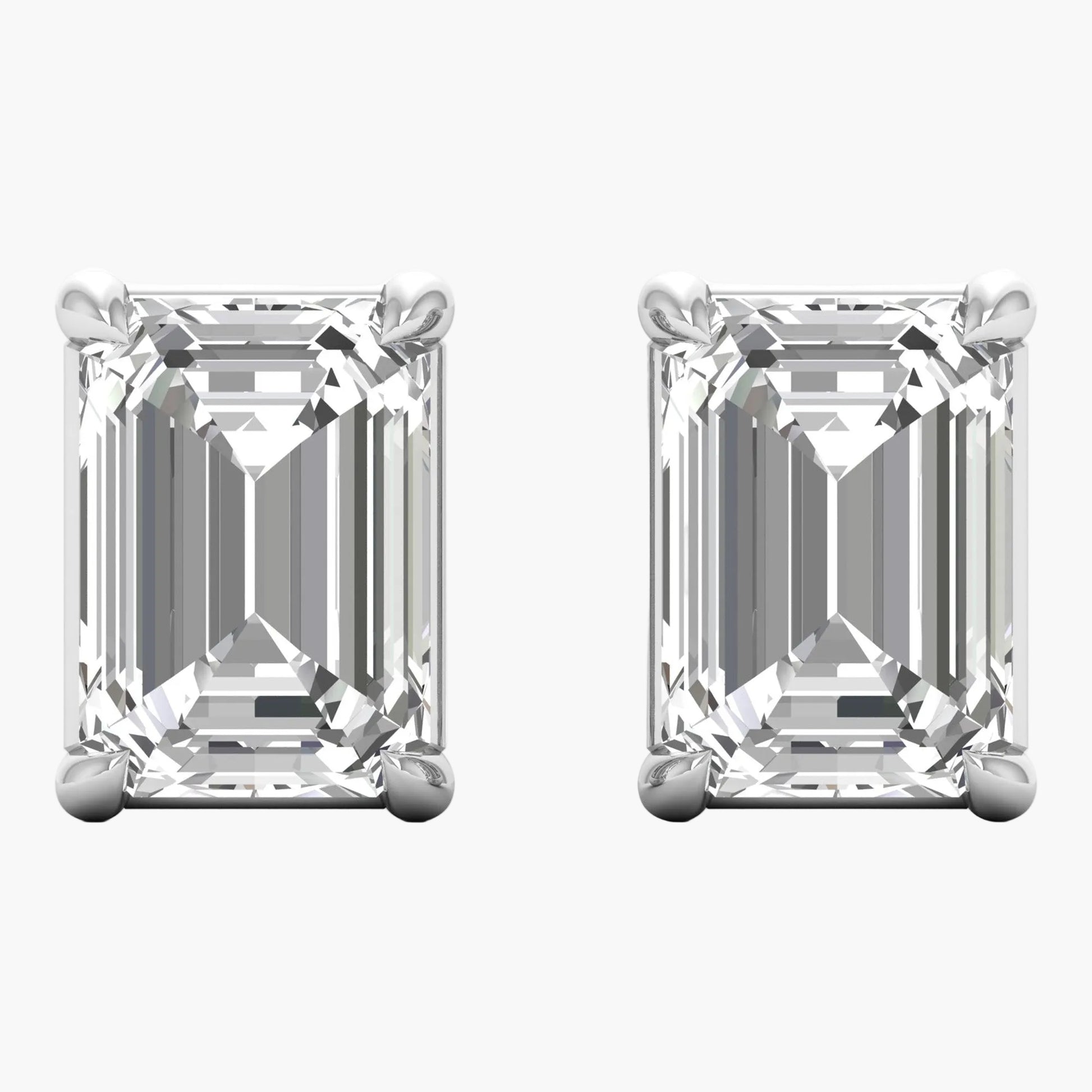 Pair of emerald-cut diamond earrings on a white background