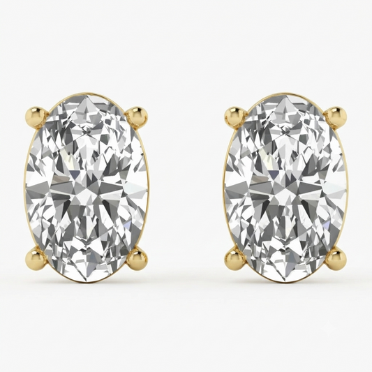 A pair of oval-cut diamond stud earrings in yellow gold four-prong settings, shown on a clean white background.