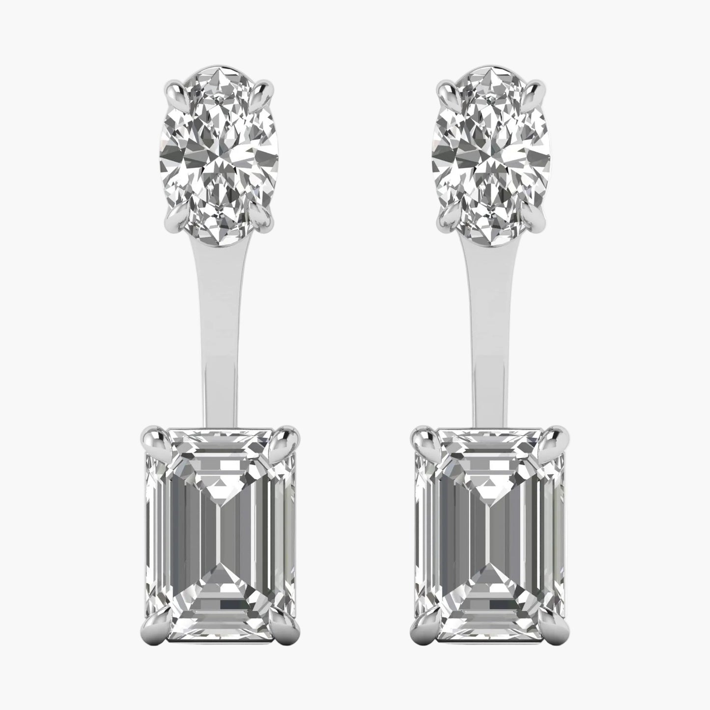Pair of diamond earrings with round and emerald-cut stones on a white background