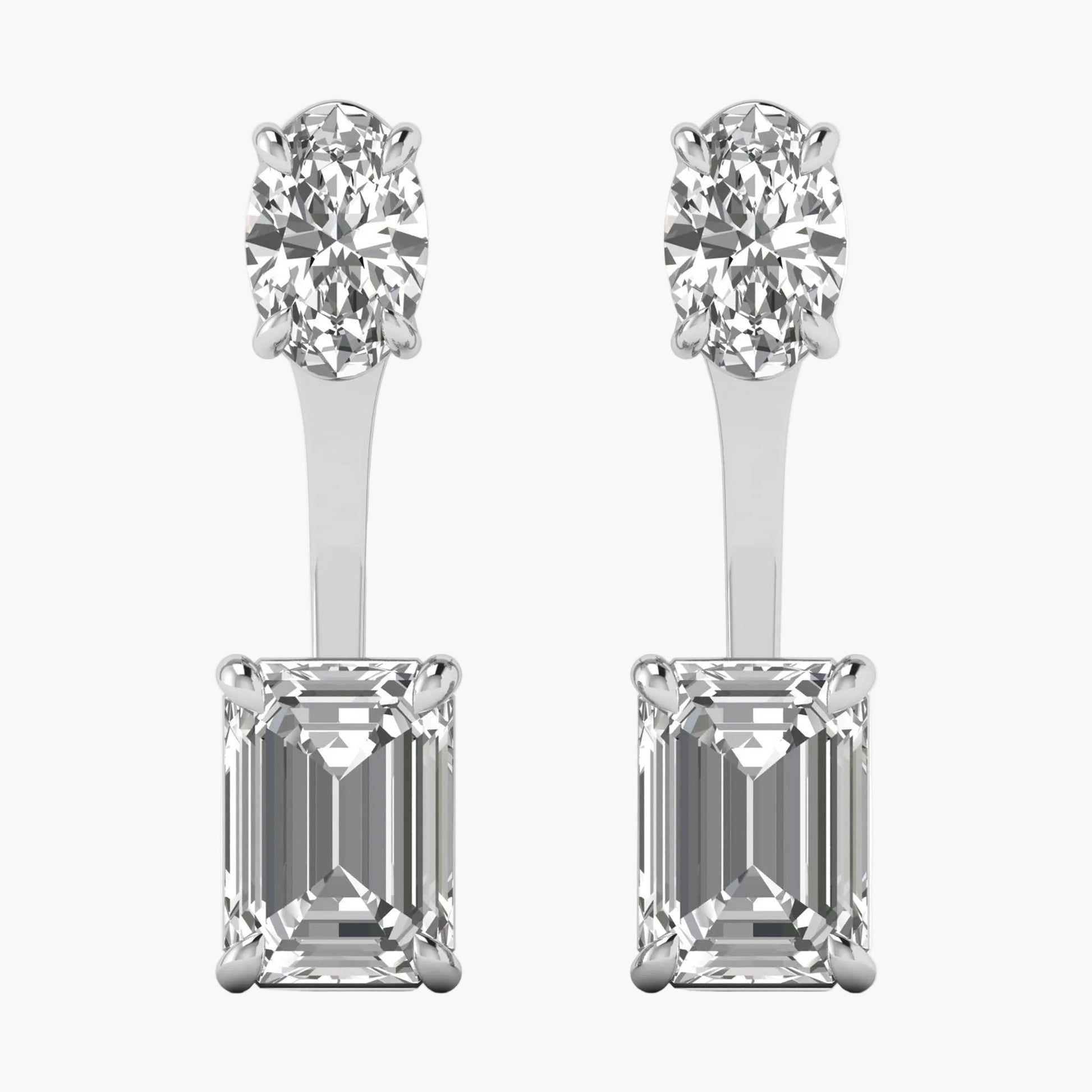 Pair of diamond earrings with round and emerald-cut stones on a white background