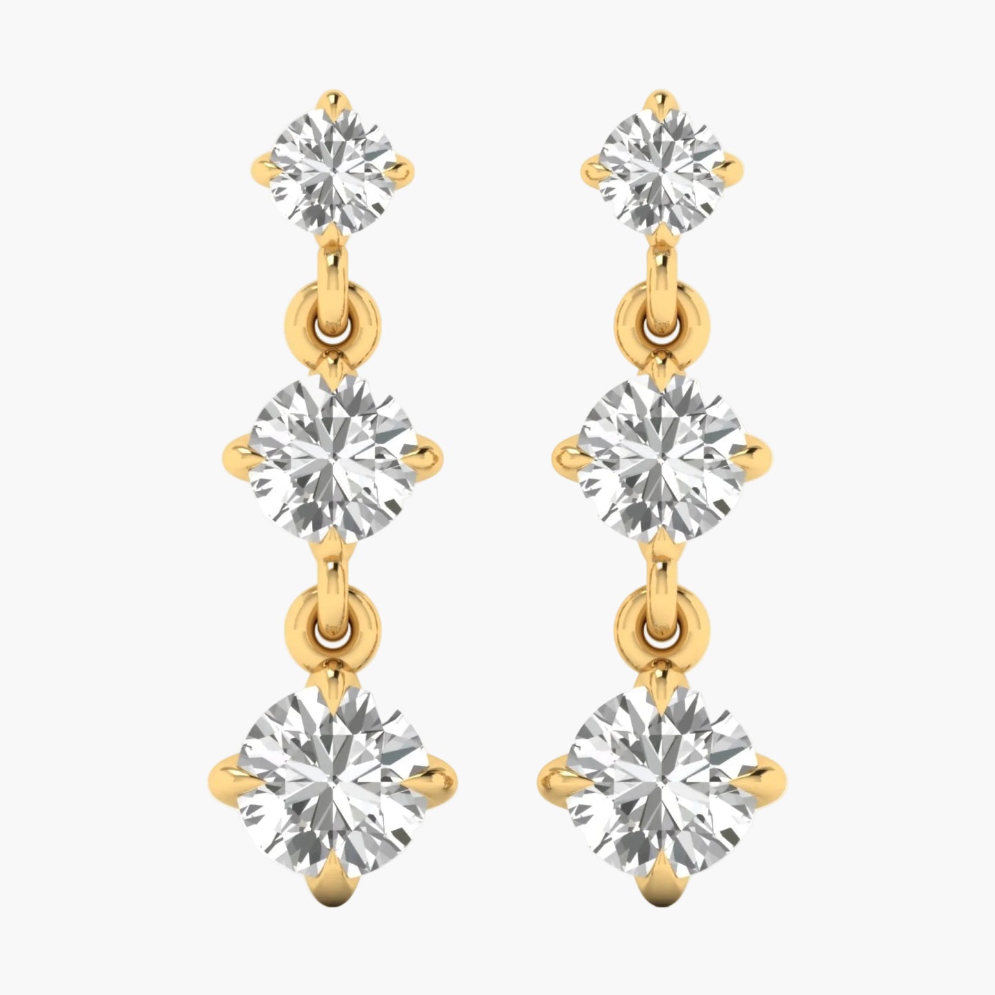 Gold and silver earrings with clear gemstones on a white background