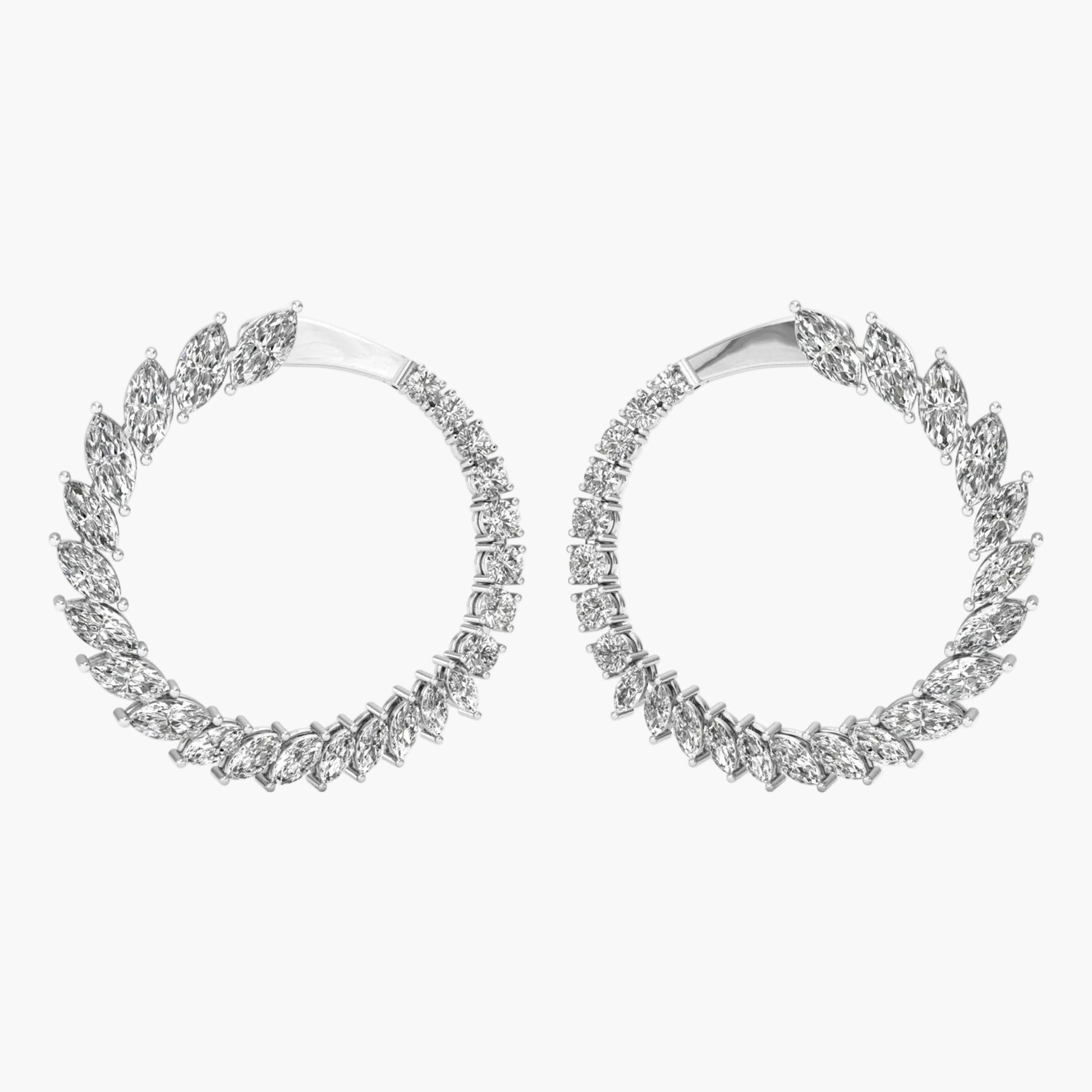 Pair of silver hoop earrings with diamond-like stones on a white background