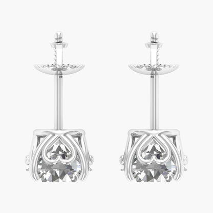 Pair of silver earrings with intricate heart designs on a white background