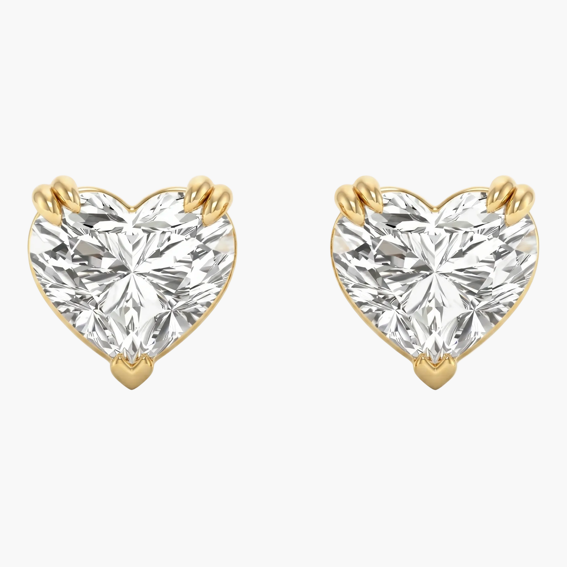 Heart-shaped diamond earrings with gold prongs on a white background