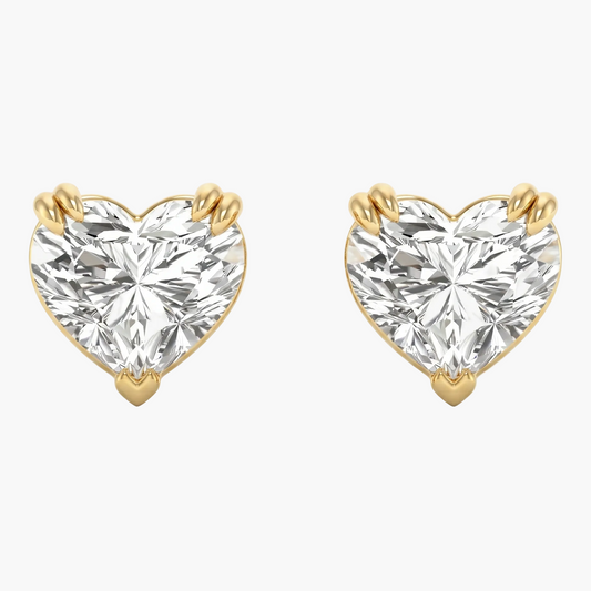 Heart-shaped diamond earrings with gold prongs on a white background