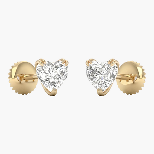 Heart-shaped diamond earrings with gold settings on a white background