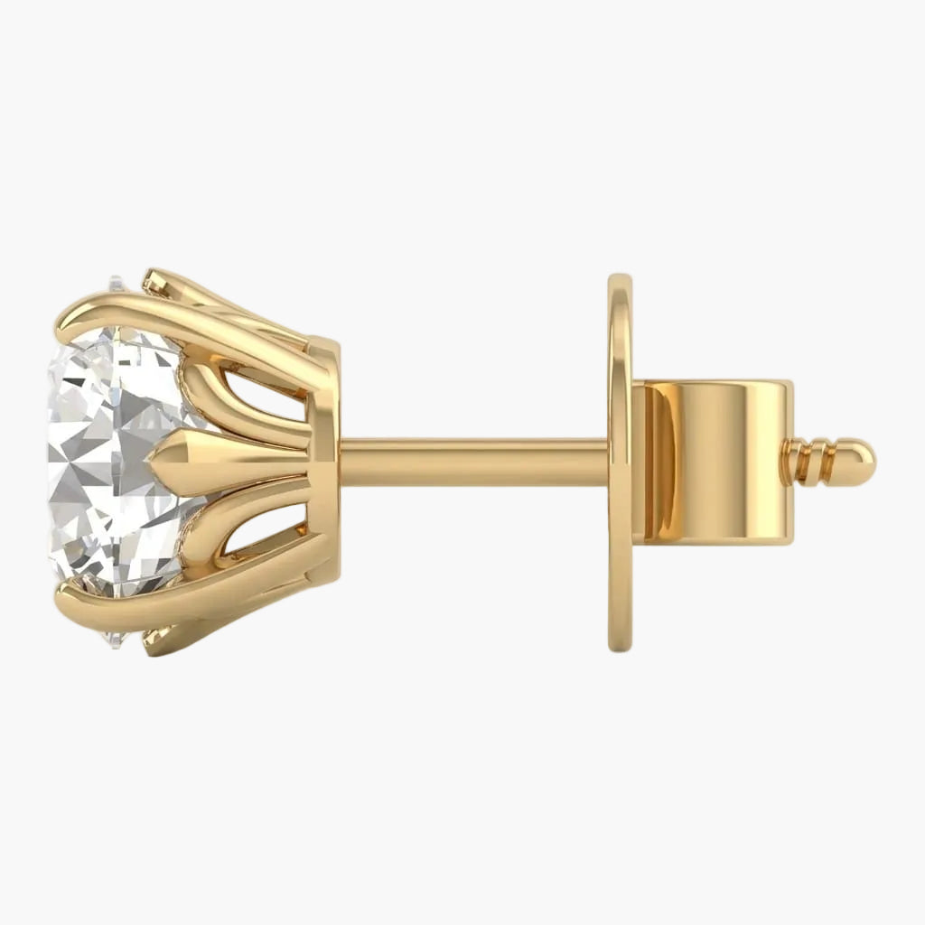 Gold earring with a clear gemstone on a light gray background