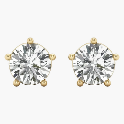 A pair of round-cut diamond stud earrings in yellow gold four-prong settings, shown against a plain light gray background.